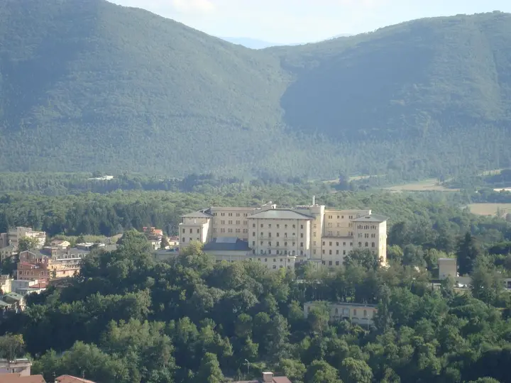 Large thermal complex building in Fiuggi among woods below forested hills