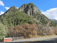 Forested rock peak and autumn oaks above Colorado Highway 133 near Avalanche Road and the ranch