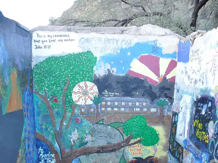 Small square soaking pool inside a mural painted concrete room at Verde Hot Springs