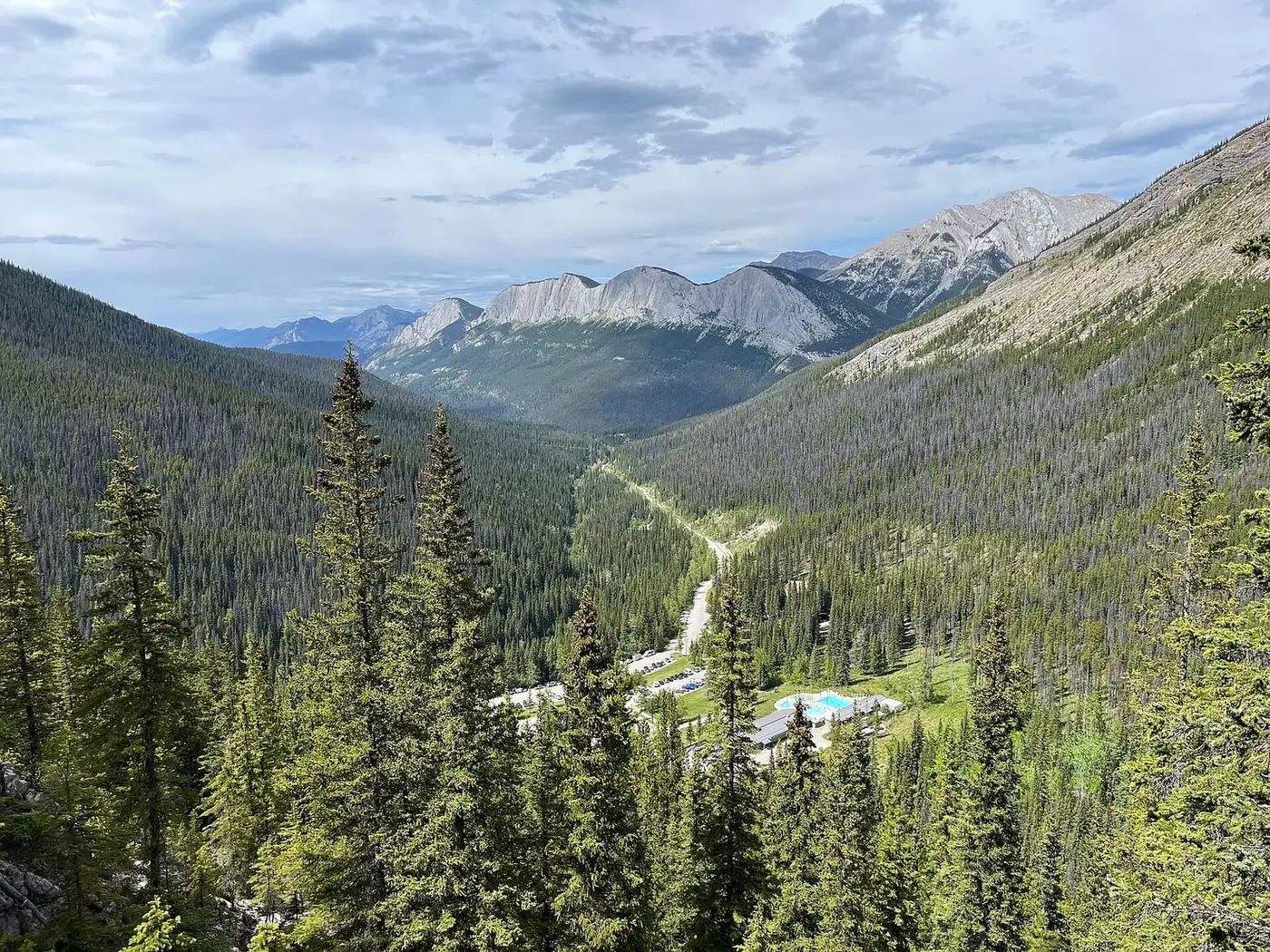 Miette Hot Springs in a forested valley seen from the Sulphur Skyline ridge with peaks beyond