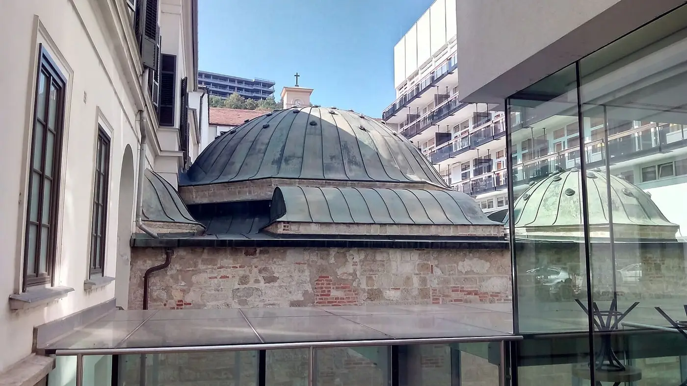 Ottoman dome of the Veli Bej Bath beside its modern glass wing in Buda