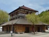 Two storey wooden Kosoyu bathhouse on the square of Yamashiro Onsen with willow trees