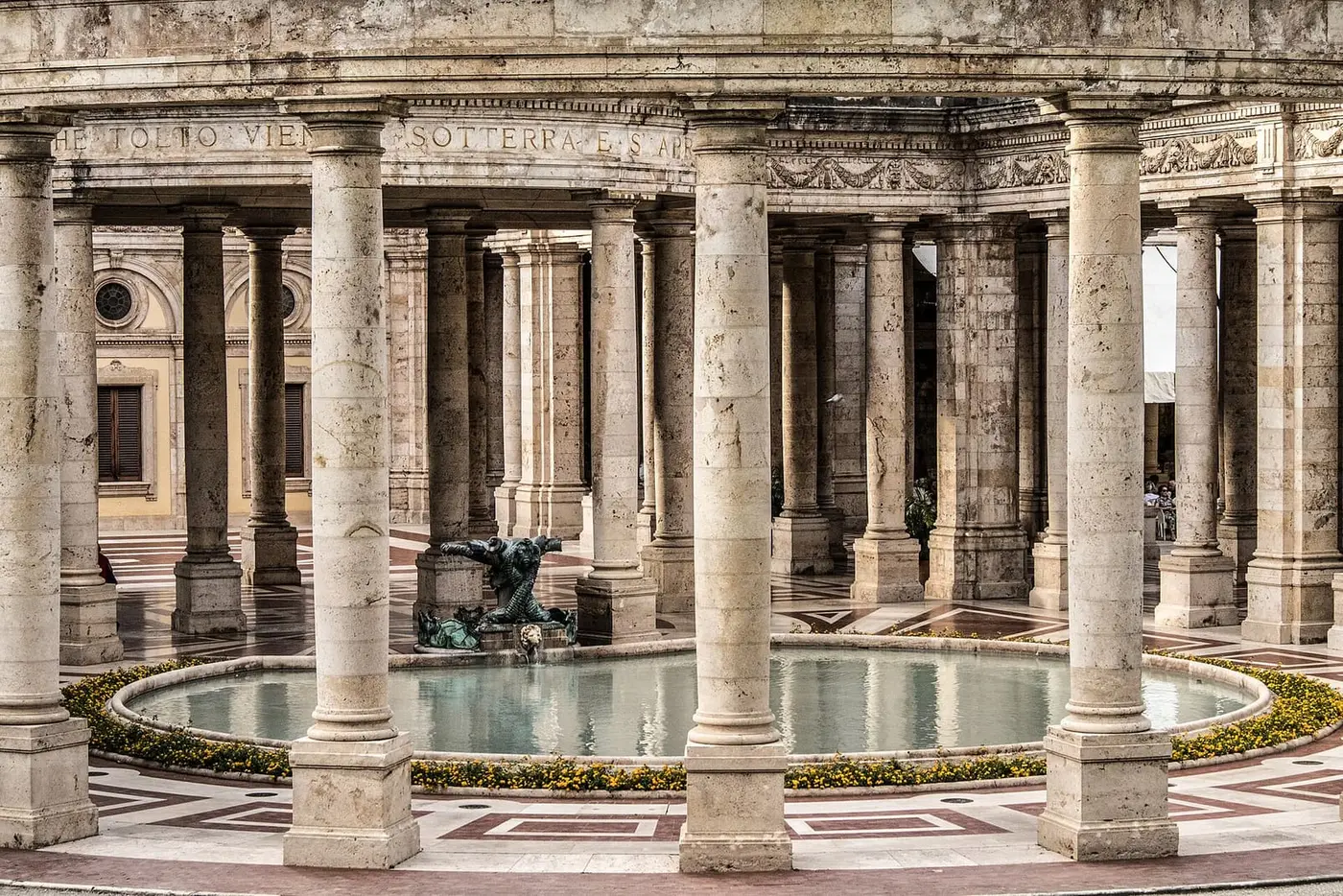 Colonnade around a round fountain pool inside the Terme Tettuccio at Montecatini