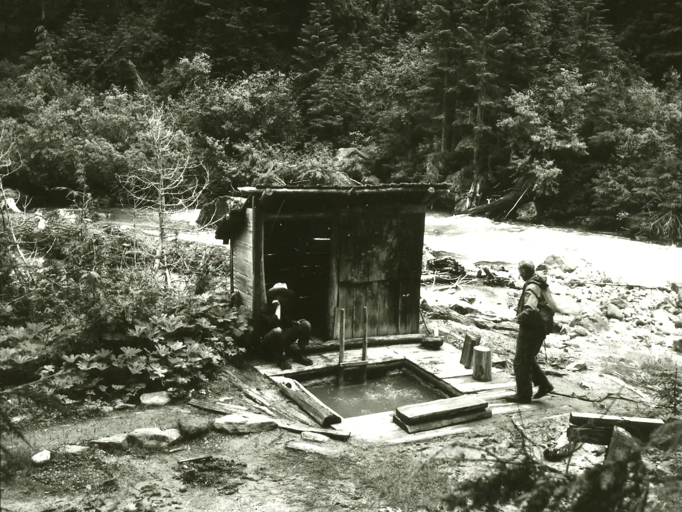 Kennedy Hot Springs in 1963, a wooden soaking pool and plank bathhouse by the White Chuck River, buried in 2003