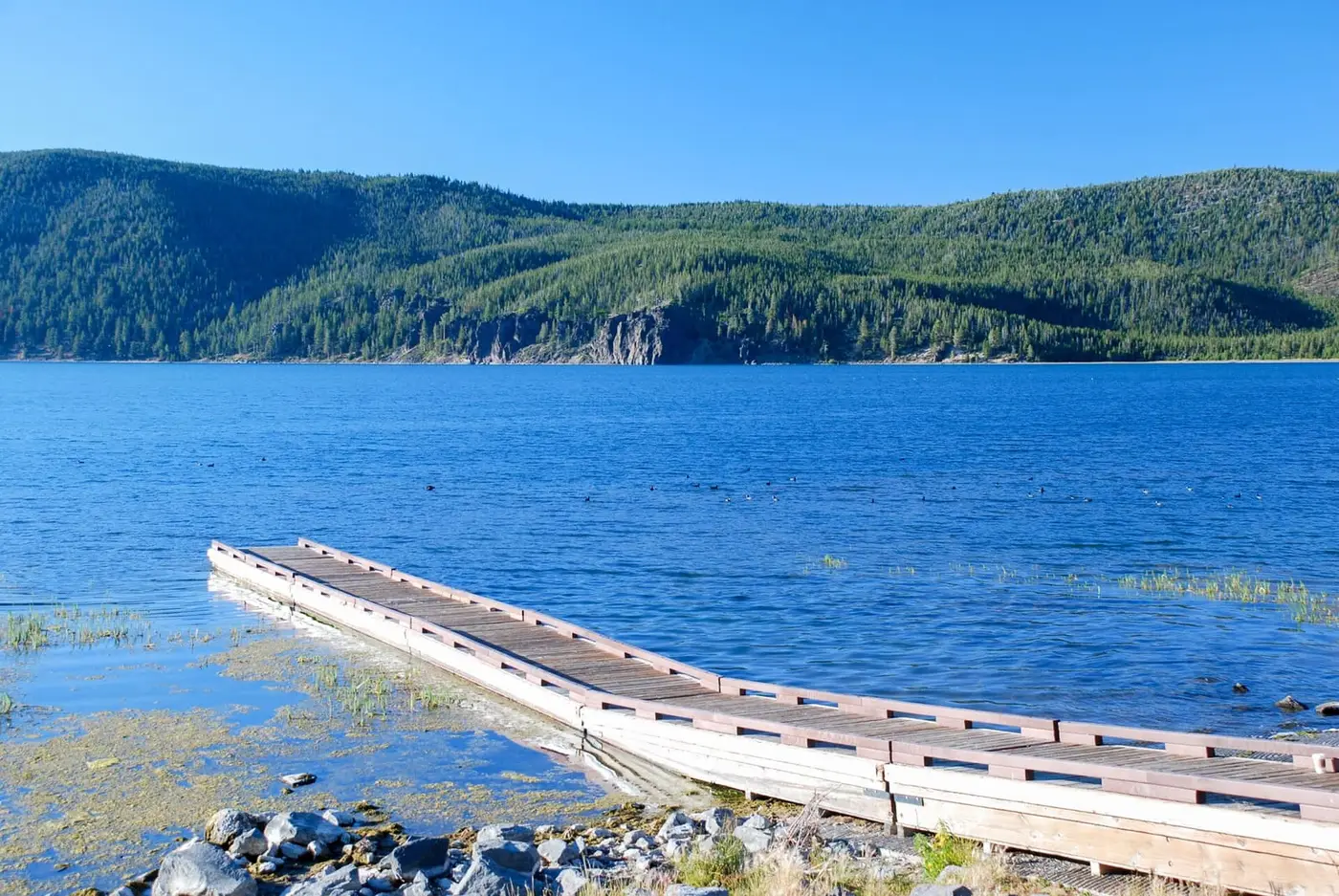 Wooden dock reaching into blue East Lake from the Hot Springs Boat Launch