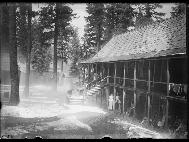 Historic black and white view of the long wooden Lehman Springs Hotel among tall pines