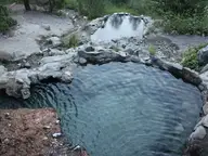 Rock-rimmed soaking pool at Loftus Hot Spring with a smaller pool above it on the rocky hillside