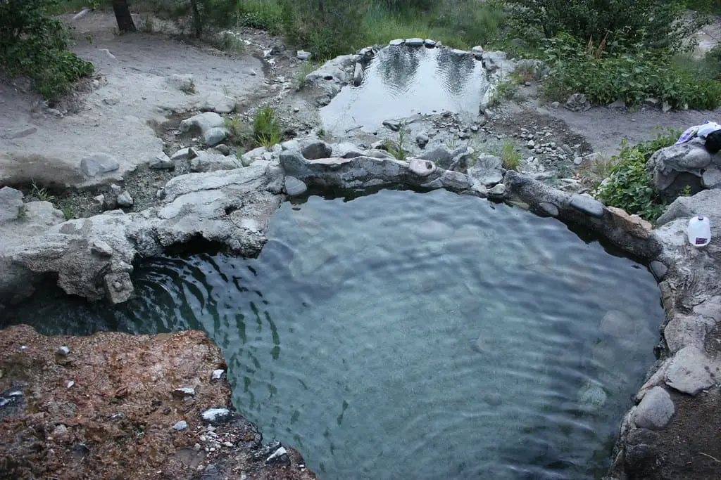 Rock-rimmed soaking pool at Loftus Hot Spring with a smaller pool above it on the rocky hillside