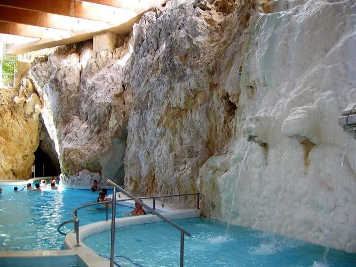 Turquoise thermal pool inside the limestone cave at Miskolctapolca with water spouting from rock