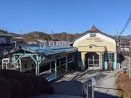 Retro Bessho Onsen Station with its blue platform roof below hills on a clear day