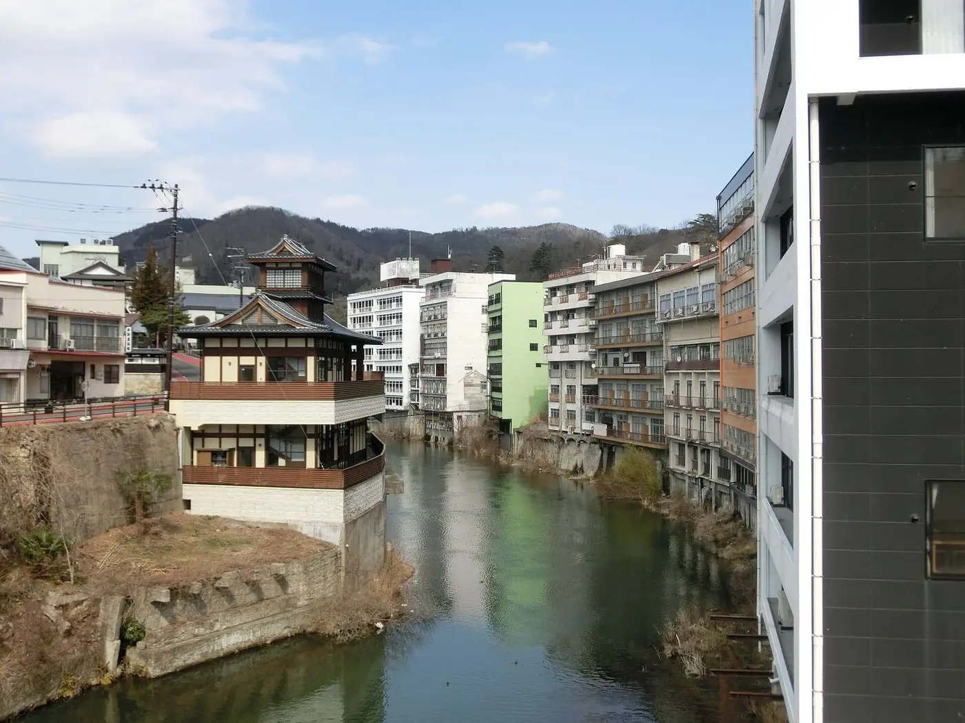 Surikami River flowing through Iizaka Onsen between hotels and a pagoda style inn