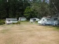 Pale green guest cabins with white decks around a grassy lawn at Doe Bay Resort on Orcas Island