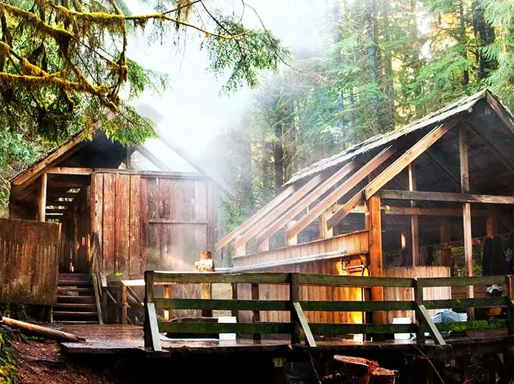 Steam rising from the wooden bathhouse decks at Bagby Hot Springs in old growth forest