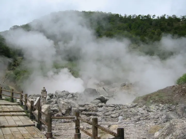 Clouds of steam rising from the Unzen Jigoku fumarole field beside a wooden walkway