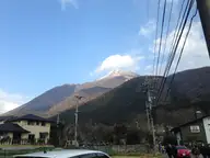 Snow capped Mount Yufu rising above houses along Yunotsubo street in Yufuin Onsen