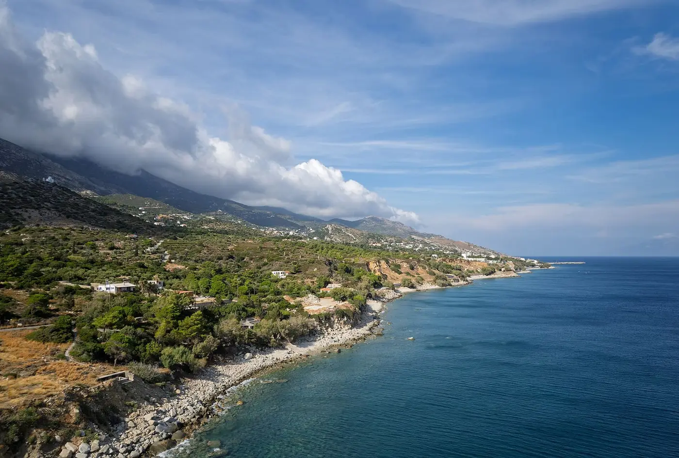 Aerial view of the rocky southern Ikaria coastline west of Agios Kirykos under clouds