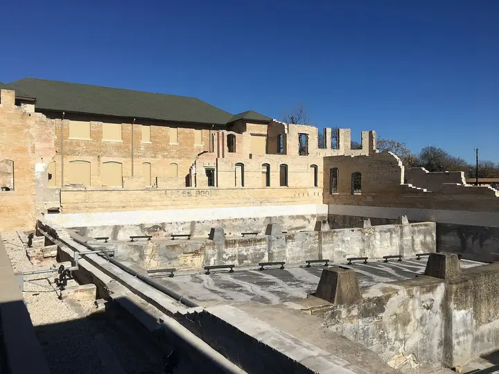 Ruined brick walls and empty concrete bathing pools of the historic Hot Wells Hotel in San Antonio