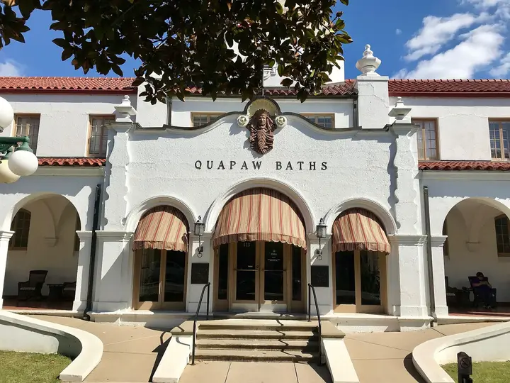 Entrance of the Quapaw Baths with its name above striped awnings and arched doorways
