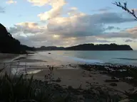 Sunset light over Hot Water Beach looking north past the rocky bluff where the hot water rises
